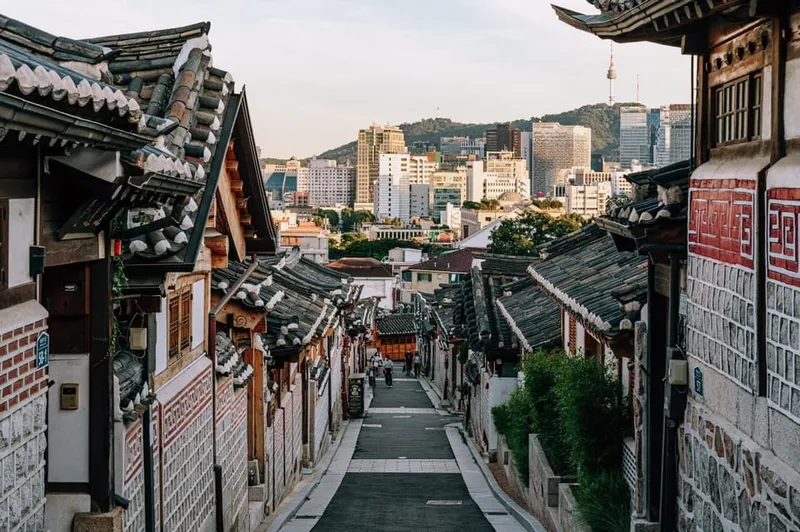 Guide serving traditional Korean sweets in a historic hanok lane in Bukchon on a seoul food tours cultural walk in Seoul, South Korea